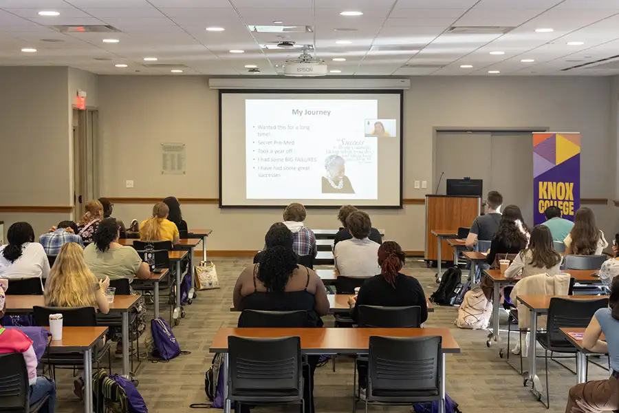 A large classroom full of students who are watching a presentation on a big screen.