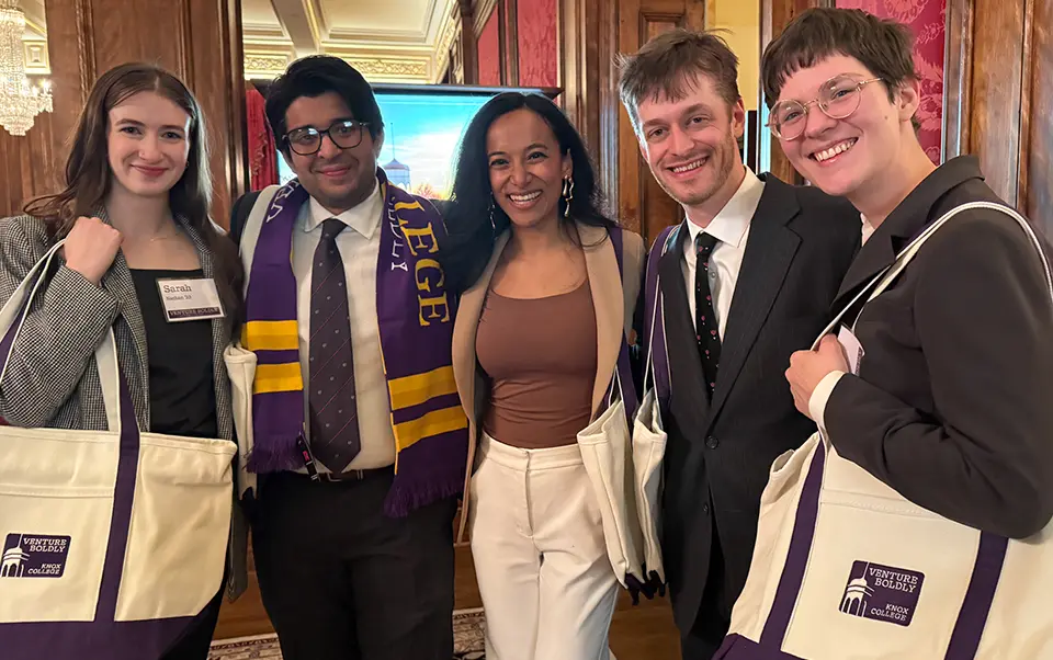 A group of 5 smiling men and women are gathered, standing with arms around each other, at Venture Boldly Washignton, DC.