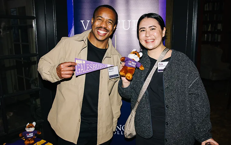 A man and woman smile while showing their Knox swag