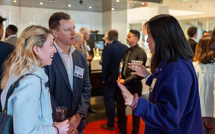 Three event attendees gather in lively conversation.